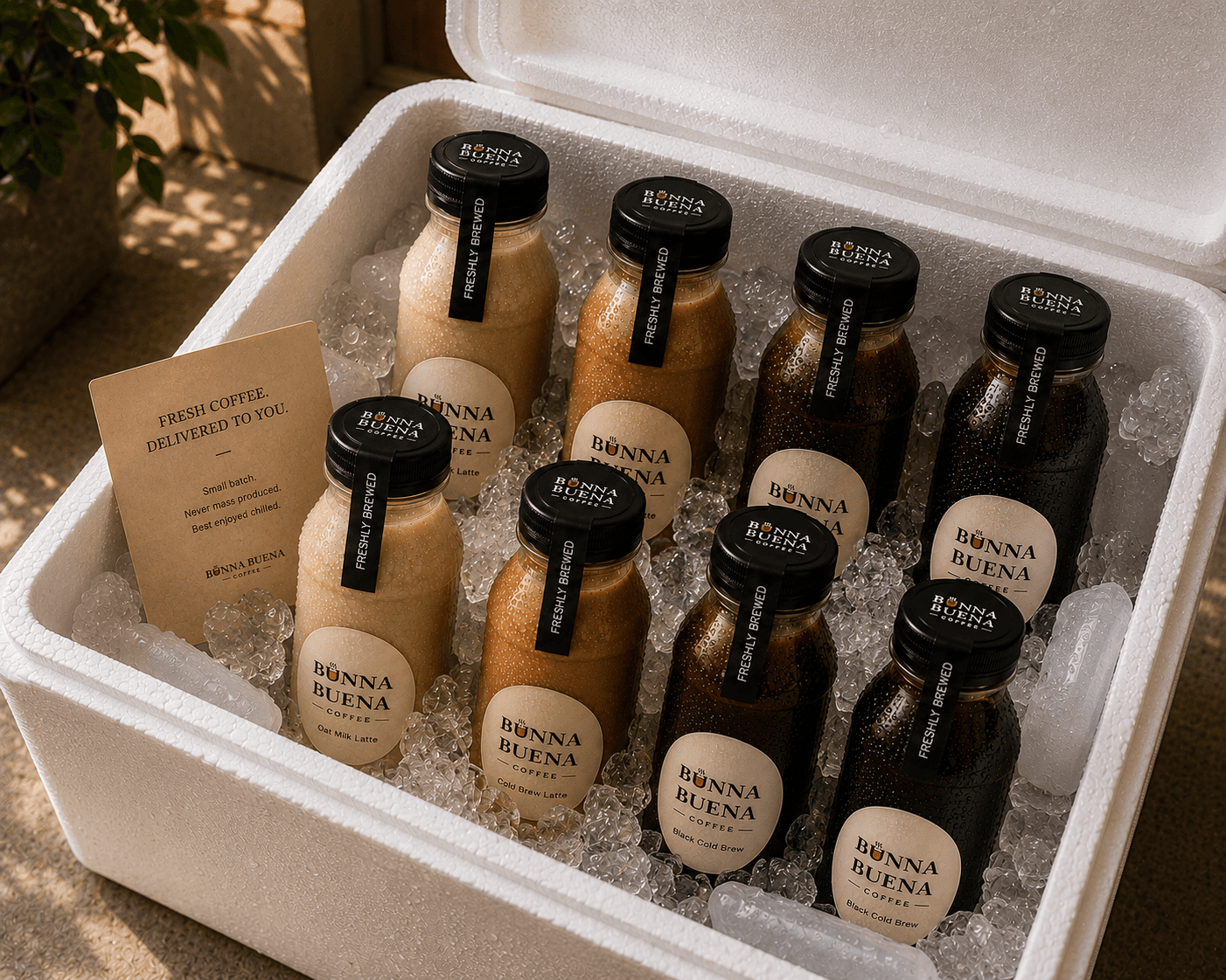 Eight chilled Bunna Buena bottles packed in ice inside a white foam cooler for delivery